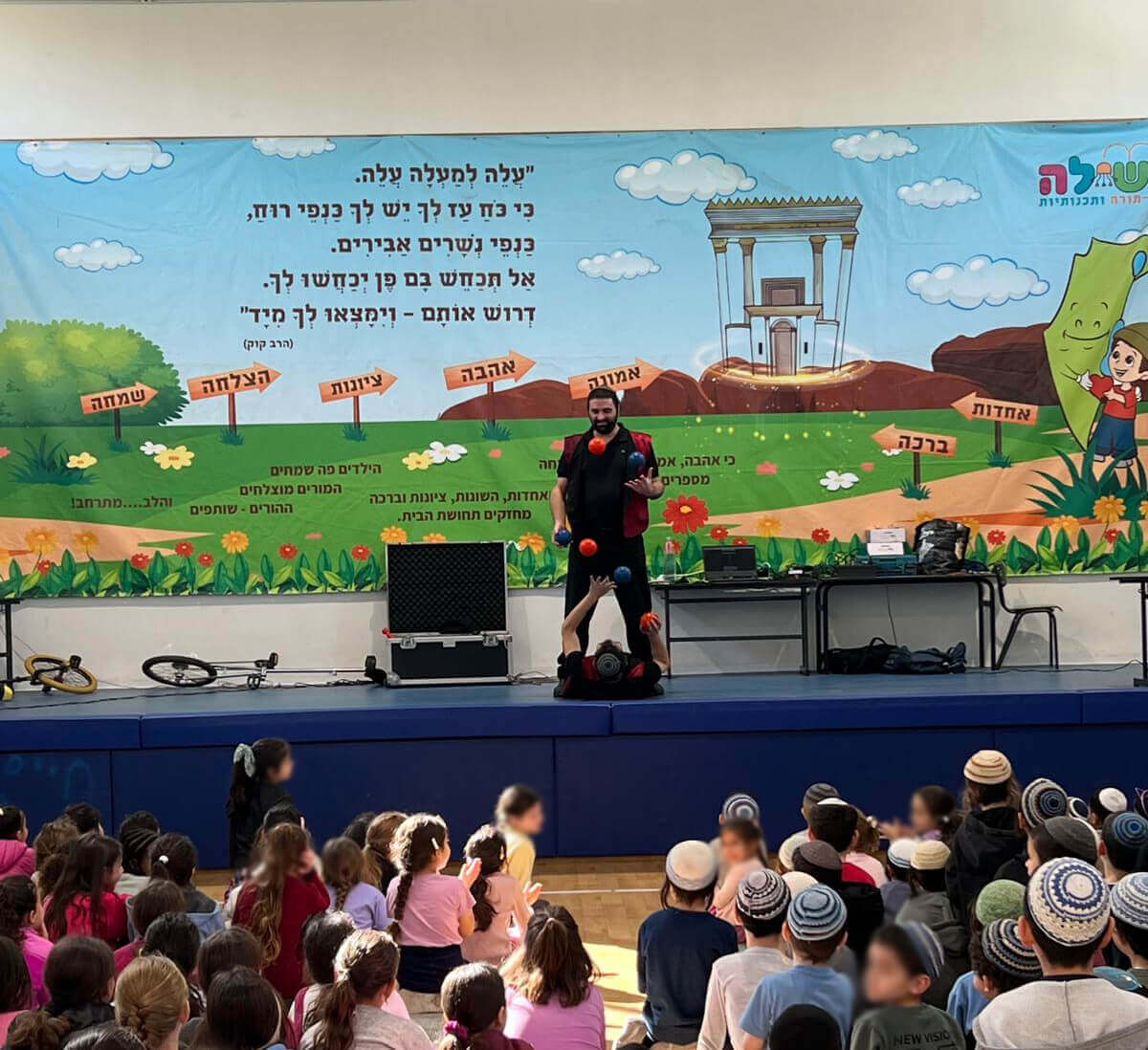 עמי ויהודה מדגימים להטוטי כדורים במופע של תיאטרון מופאש מול קהל ילדים